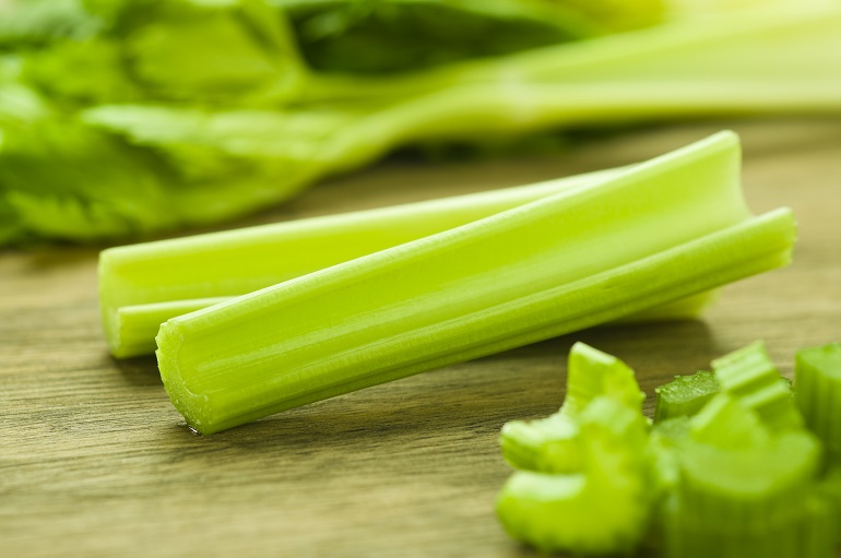 Cut celery sticks and leaves on wooden table अजवाइन के रोचक तथ्य, पोषण मूल्य और पौधों की जानकारी