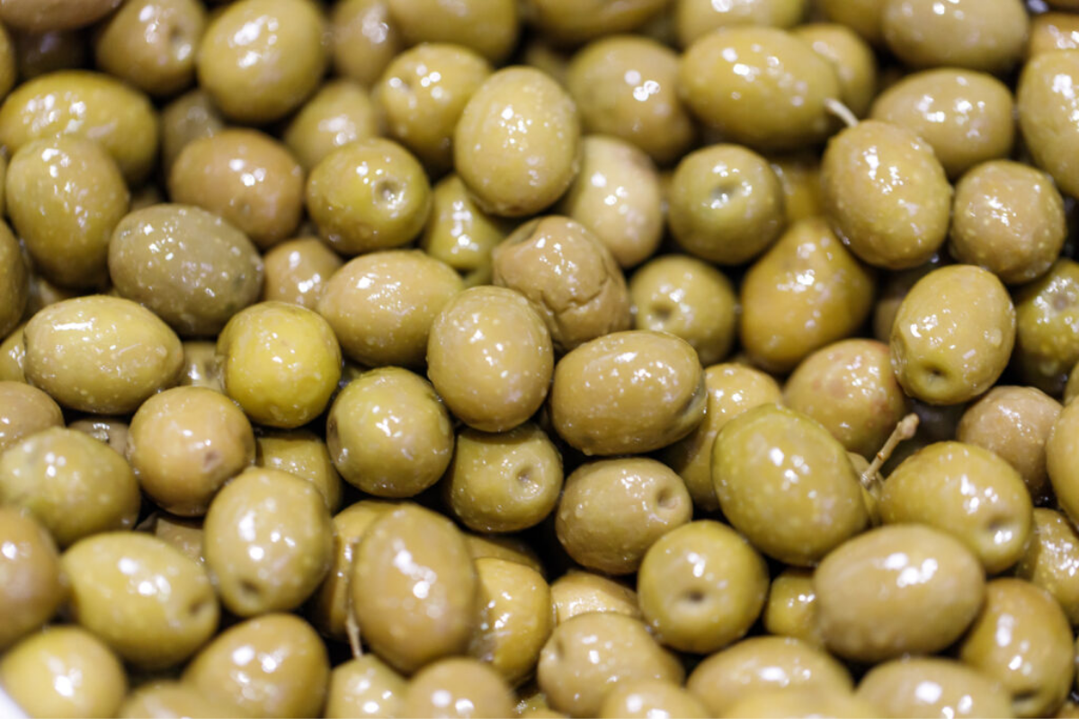 Close-up of green table olives in brine
