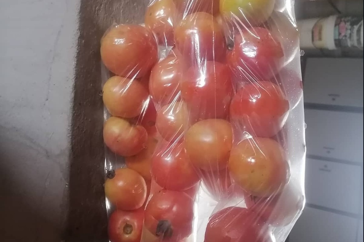 Fresh tomatoes packed in a clear plastic bag, ready for sale