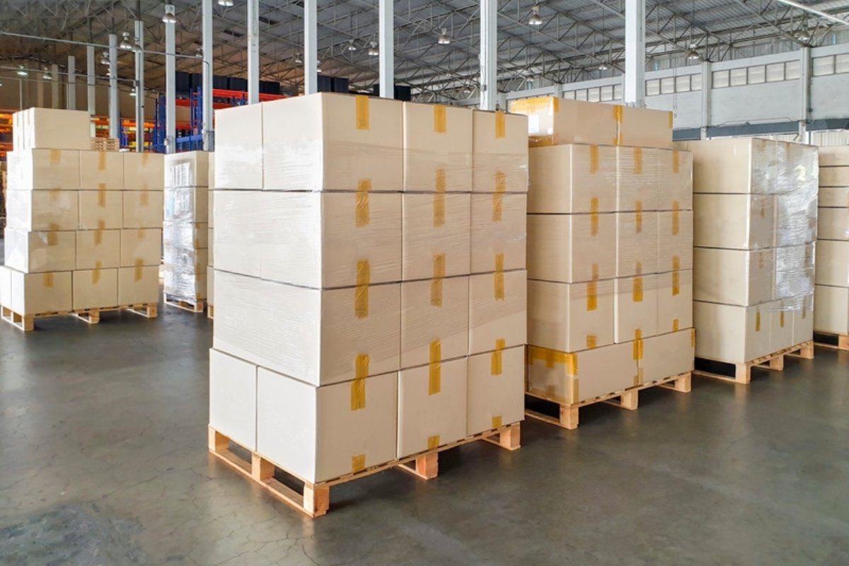 Scatoloni avvolti nel film e impilati su pallet di legno in un grande magazzino