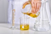 Olive oil poured between beakers in a laboratory EU food inspectors trace fraud with an AI tool while olive oil checks still vary by country